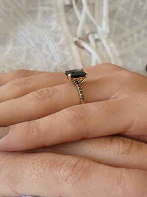 emerald cut black diamond ring on finger