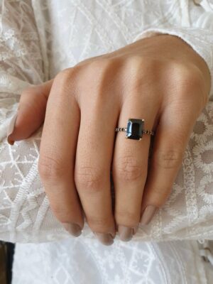 emerald cut black diamond ring on finger